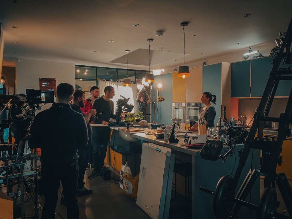 Wide shot of all the crew filming in the kitchen